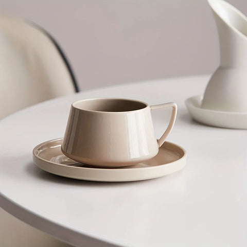 Taza de té o café contemporánea y elegante con platillo a juego